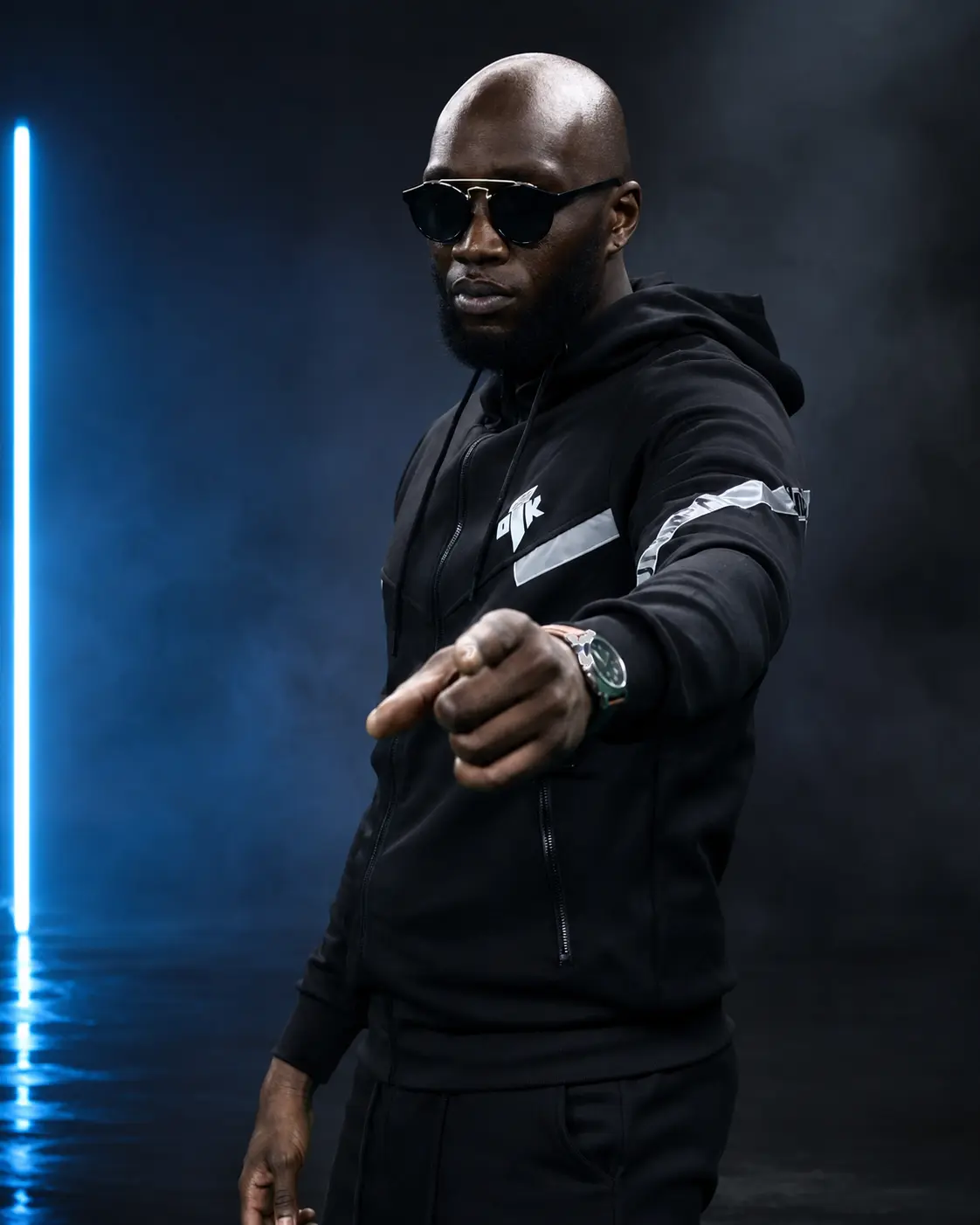 Look noir UN10BAL dans un studio bleu