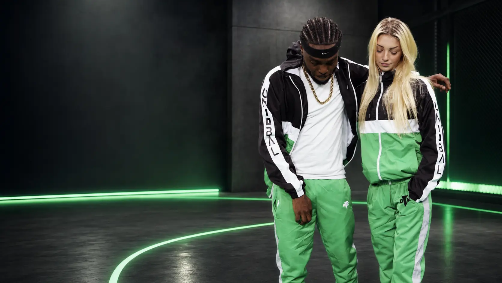 Duo portant la collection verte et noire UN10BAL dans un studio sportif